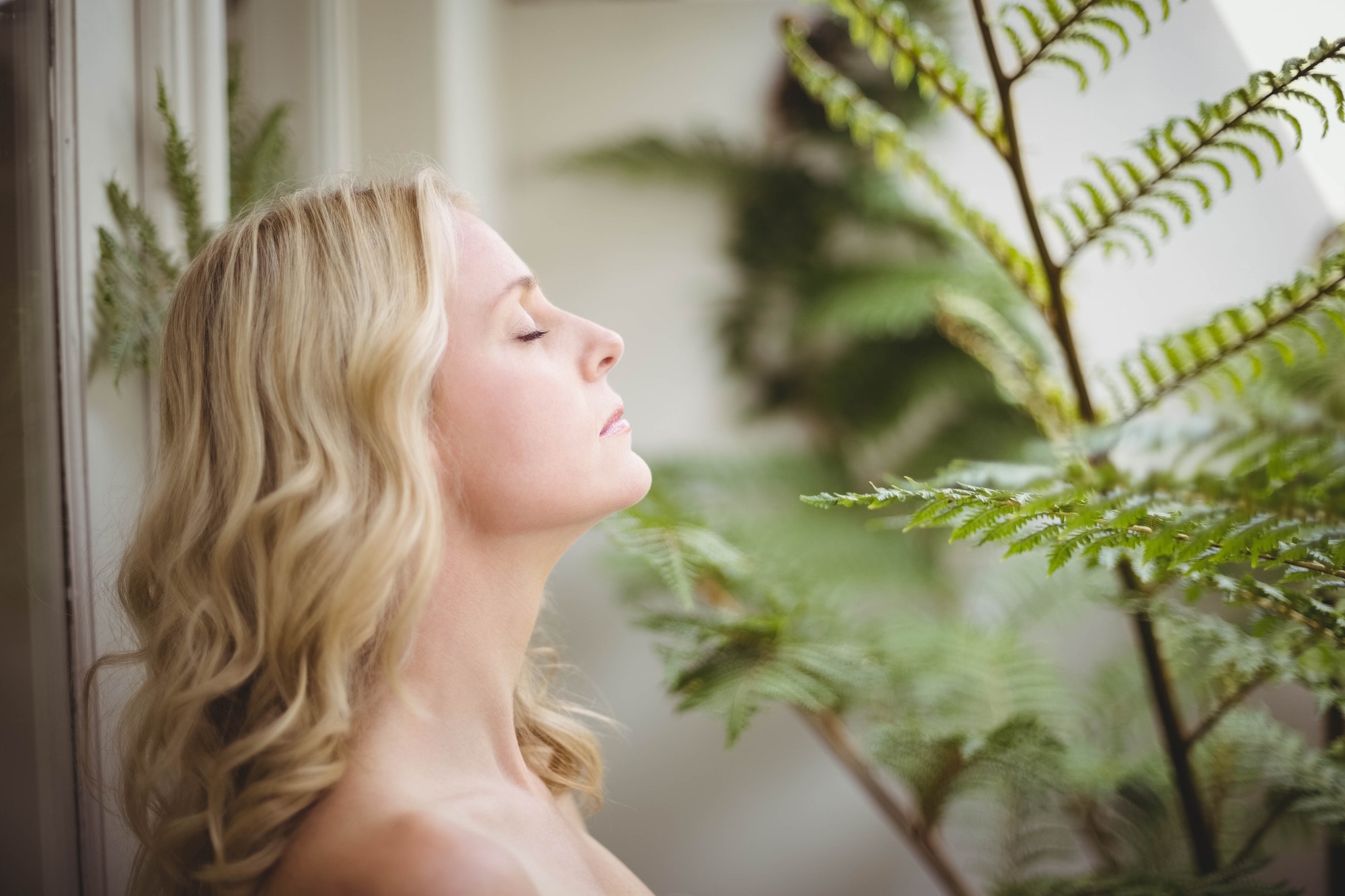 Beautiful woman smelling leaves in the living room